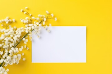 Crisp white envelope with white baby's breath flowers against a sunny yellow backdrop.
