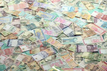 Many banknotes of different currency. Background of big amount of random money bills close up