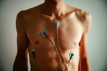 Monitoring heart vitality: A young man's torso adorned with an EKG, bathed in the soft hues of natural daylight. - 749255787