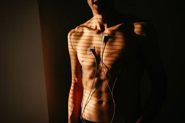 EKG chronicles of well-being: A young individual's torso adorned with medical precision, illuminated by the grace of natural light