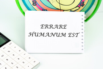 Latin quote Errare humanum est, meaning It is human nature to make mistakes. Mistakes are inherent in human existence. Text written on a white card - obrazy, fototapety, plakaty