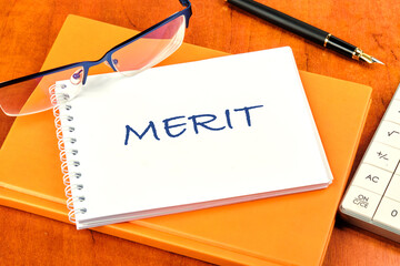 Business and merit concept. MERIT written on a clean white notebook