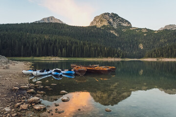 Boats and kayaks on the lake with forest and mountain in the background, Black lake, Durmitor, Montenegro