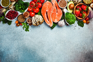Top view. Healthy food selection on gray background. Detox and clean diet concept. Foods high in vitamins, minerals and antioxidants. Anti-aging foods. - obrazy, fototapety, plakaty