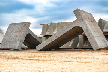 Large reinforced concrete structures at the construction site. Preparation for the installation of reinforced concrete products. Construction work on the construction of foundations.