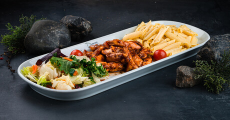 Lunch pasta with chicken, mushrooms, onions, sweet pepper, sauce and fresh vegetable salad of carrots, lettuce, cabbage and tomatoes.