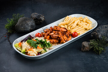 Dinner Penne pasta with chicken, mushrooms, onions, sweet pepper, sauce and fresh vegetable salad of carrots, lettuce, cabbage and tomatoes.