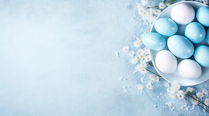 A bowl with colored eggs and some fresh spring flowers on light blue background with copy-space....