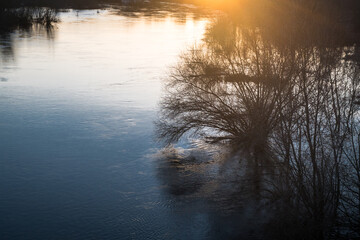 Wysoki stan wody w rzece, zachód słońca.