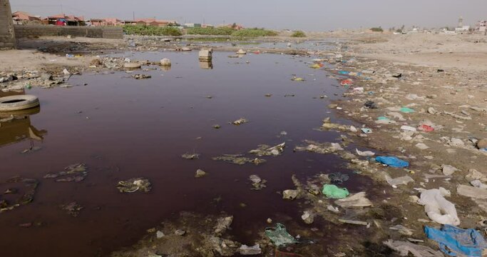 Close-up panning. Stinking stagnant polluted water and horiffic plastic pollution Dakar, Senegal