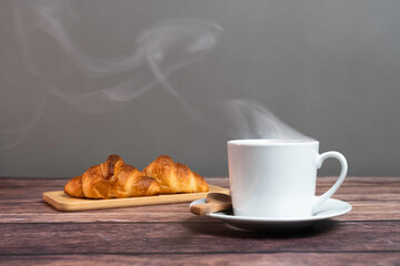 湯気の上がる温かいコーヒーとクロワッサン