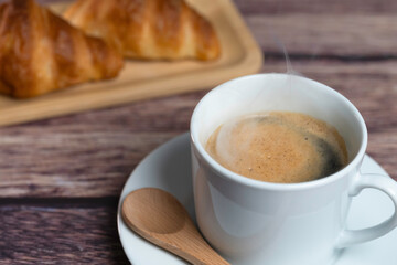 湯気の上がる温かいコーヒーとクロワッサン