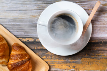 湯気の上がる温かいコーヒーとクロワッサン