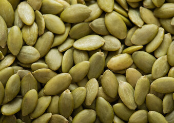 Healthy peeled green pumpkin seeds top view macro background.Top view.