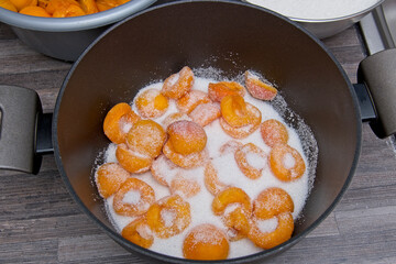 Sugar covering the apricot halves in a saucepan