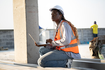 Portrait very tired worker African woman with holding notebook computer at construction site	