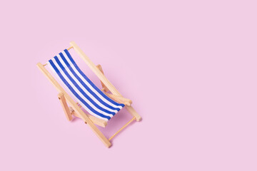 Sunlounger, beach chair near the sea, holiday destination, seaside retreat, pink background
