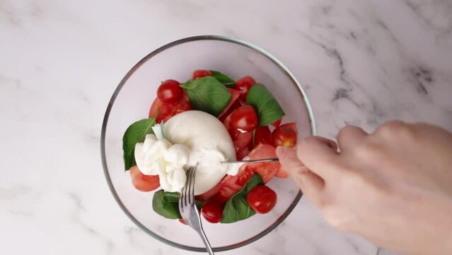 Burrata with tomatoes and basil salad, creamy mozzarella, ripe tomatoes, and fragrant basil leaves