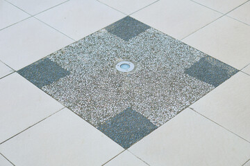 lights embedded in the floor in the middle of the tiles on the pedestrian street