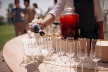 The waiter fills the glass with champagne. Catering, welcome drink, service, alcohol. A solemn event