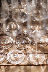 Many empty champagne or wine glasses sparkle in the sun. Preparation for a reception or holiday, a container for alcoholic beverages. Restaurant, catering, service
