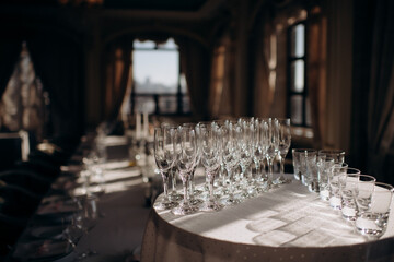 Many empty champagne or wine glasses sparkle in the sun. Preparation for a reception or holiday, a container for alcoholic beverages. Restaurant, catering, service