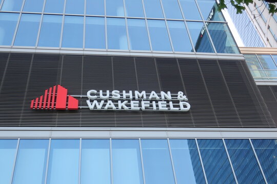 Cushman and Wakefield signage, logo, emblem on the office facade. American global commercial real estate services firm. WARSAW, POLAND - MAY 21, 2023