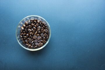 Roasted coffee beans in glass containers. Coffee beans packed in a clear glass