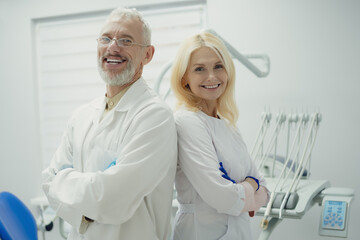 Male and female dental doctors wearing face sitting at his clinic.