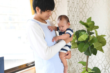乳幼児を抱っこするアジア人の男性保育士