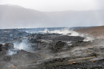 Close up view of cracked lava crust or ingenious rock and steam, cooled down from 2021 eruption of volcano Mt. Fagradalsfjall in Geldingadalir valley on Reykjanes Peninsula near Grindavik, Iceland