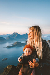 Mother with baby traveling in Norway family healthy lifestyle outdoor summer vacations woman hiking with infant child in mountains of Lofoten islands active trip, Mothers day - 749356755