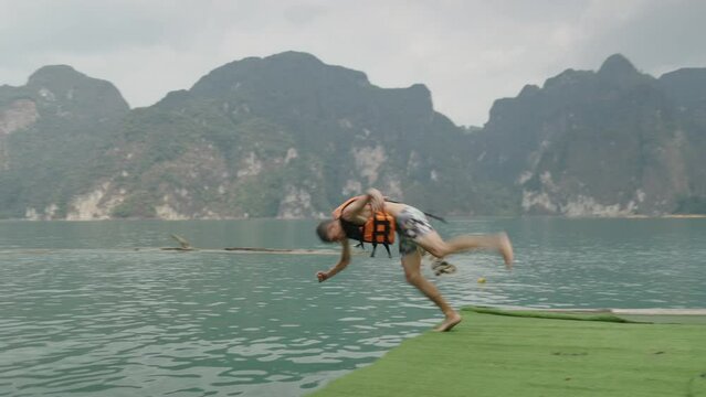 A man in a lifejacket jumps into the lake
