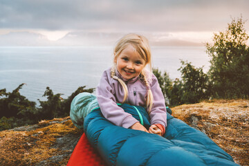 Child girl in sleeping bag camping gear active travel family summer vacations bivouac outdoor, 4 years old kid smiling adventure eco tourism healthy lifestyle - 749357757