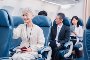 Naklejka premium 機内エンターテイメントを楽しむ高齢の女性