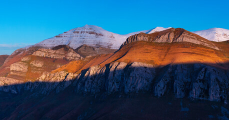 Obraz premium Last lights of the peaks of the Miera Valley in winter, aerial view of the Miera River Valley. Landscape in winter. Valleys Pasiegos. Cantabria. Spain. Europe