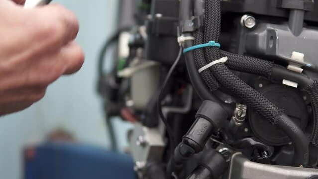 A technician diagnoses the serviceability of spark plugs in an injection-injected outboard motor. Repair of two-stroke and four-stroke injection and carburetor engines.