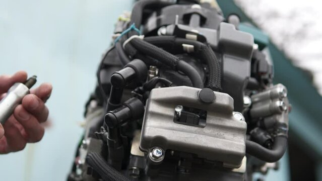 A technician diagnoses the serviceability of spark plugs in an injection-injected outboard motor. Repair of two-stroke and four-stroke injection and carburetor engines.