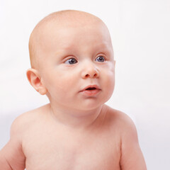 Young, cute and face of baby on a white background for child development, youth and growth. Curious, facial expression and closeup of isolated newborn for childhood, wellness and adorable in studio