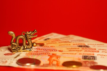 A figurine of a Chinese dragon with money. Financial symbol.