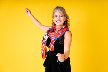 young pretty cheerful woman dancing on a yellow background with copy space for text.