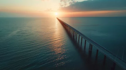 Fototapeten Aerial view of panorama: large infrastructure bridge over the sea, long bridge, blue colors, sunset, © ND STOCK