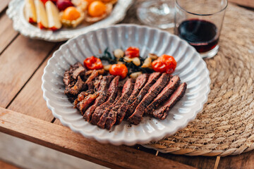 Vibrant red chili peppers and assorted spices in a wooden bowl, a fresh and healthy addition to your kitchen ingredients, showcasing organic and natural elements with a touch of greenery in a glass