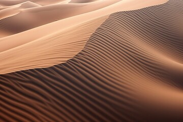 Aerial shot of wind-swept sand dunes, creating wavy patterns