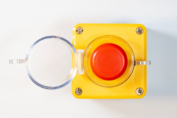 Large red emergency stop button see from above, top view, with open cover, industrial workplace...