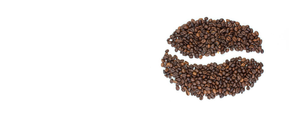A pile of coffee beans on a white background in the shape of a cup and saucer. Top view. Banner.