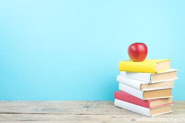 Books stacking. Books on wooden table and blue background. Back to school. Copy space for ad text.