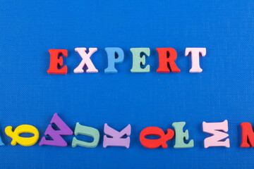 EXPERT word on blue background composed from colorful abc alphabet block wooden letters, copy space for ad text. Learning english concept.