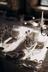 The table is set with elegant glasses for alcohol, napkins and tableware. Dinner service, catering, restaurant, formal dinner