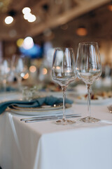 The table is set with elegant glasses for alcohol, napkins and tableware. Dinner service, catering, restaurant, formal dinner